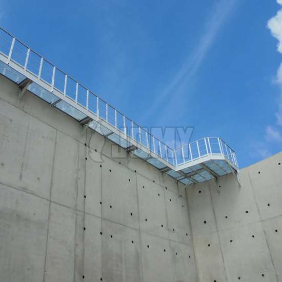 Industrieel aluminium loopbrug gebruikt op een betonnen opslagtank.
