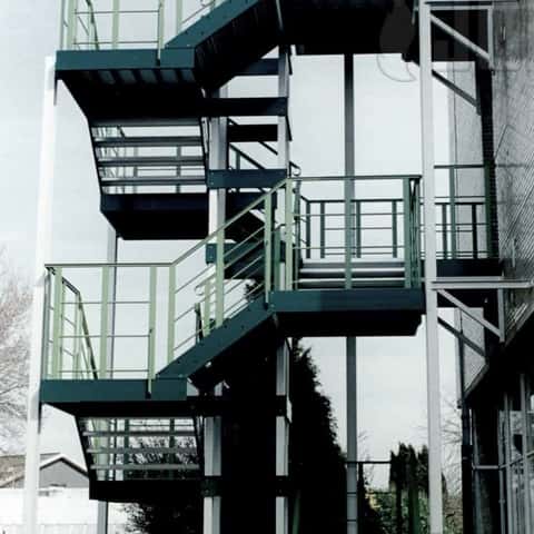 Gelakte aluminium trap met vierkante looplijn met centrale kolommen afsteunnend op het maaiveld