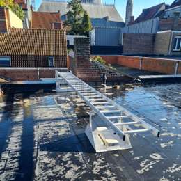Glijdende ladder op het dak die op het dak kan worden verborgen en kan worden neergelaten om vanaf het dak van een stadshuis in veiligheid te komen.