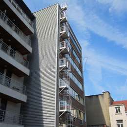 Kooiladder voor brandevacuatie vanuit een raam, met meerdere toegangsbalkons aan de gevel van een kantoorgebouw met 7 verdiepingen.