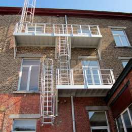 Brandevacuatie oplossing voor meerdere ramen en bestaande uit balkons, kooiladders en een uitschuifbare ladder voor de evacuatie van een flatgebouw.