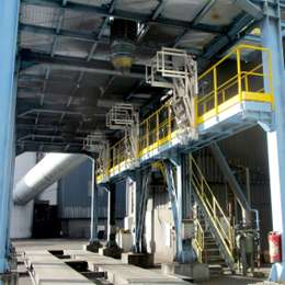 Draaibare aluminium veiligheidskooi met trap, bevestigd op een platform, voor toegang tot tankwagens van bovenaf.