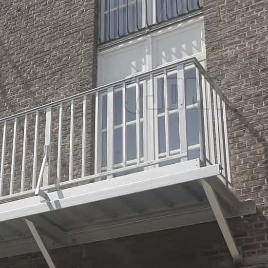 Een Jomy aluminium toegangsbalkon met een borstwering met verticale buizen.