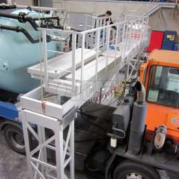 Aluminium industrieel hefbrugplatform dat wordt gebruikt voor toegang tot de uitrusting van tankwagens voor onderhoud.