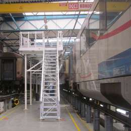 Toegangsplatform en trappen voor het werken aan de bovenkanten van treincabines in een werkplaats.