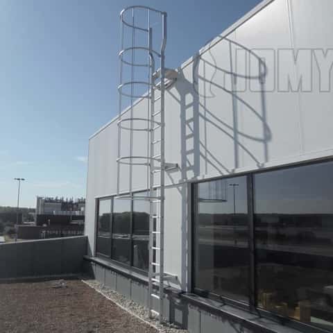 Een aluminium kooiladder met verbrede ladderbomen bovenaan voor makkelijkere daktoegang