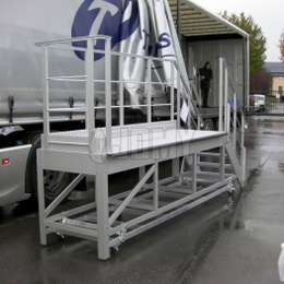 Aluminium mobiel platform met trappen en leuningen, gebruikt om op tuck trailers te klimmen.
