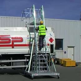 Operator klimt op een mobiele ladder die wordt gebruikt om toegang te krijgen tot mangaten van tankwagens.