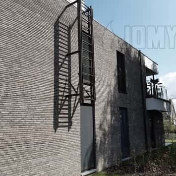 Vaste ladder op 60 cm van de muur geïnstalleerd met een uitschuifbaar onderste ladderdeel en gepoederlakt